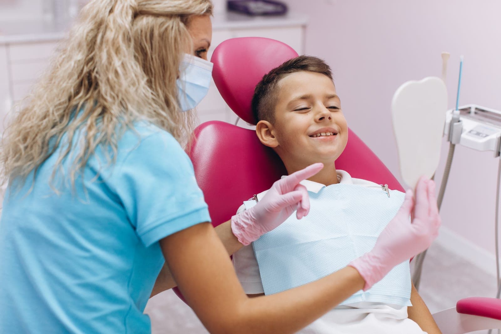 A friendly dentist showing a child their smile at AllClear Dental Centre