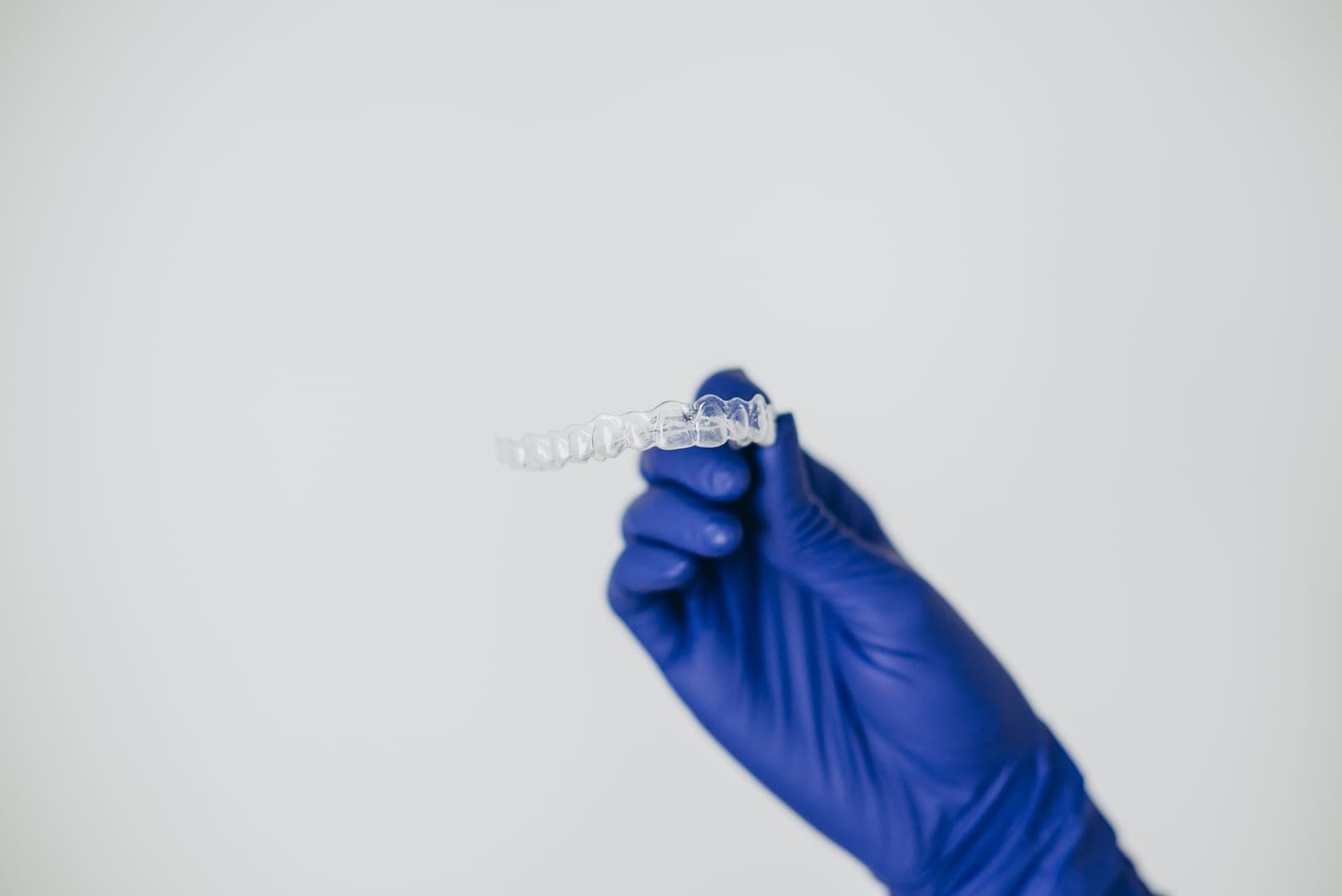 A clear aligner held up, used for discreet teeth straightening