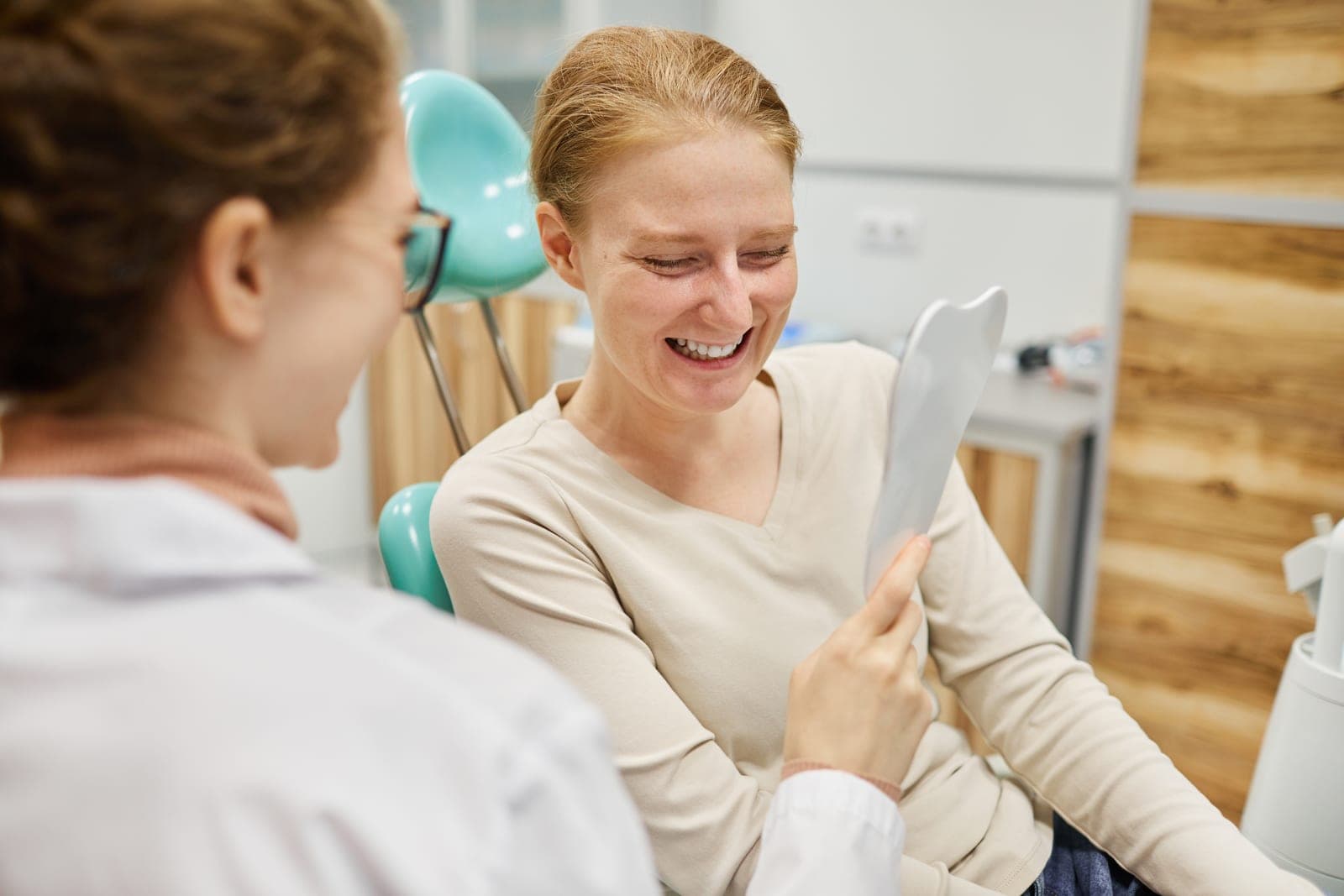 A happy patient admiring their new smile with their dentist at AllClear Dental Centre